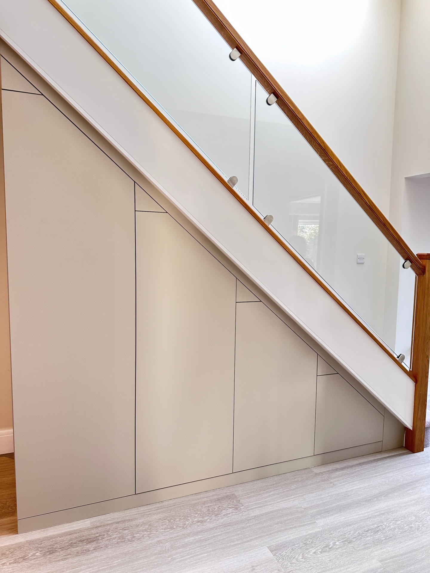 Seamless bespoke cupboards fitted to the full shape of a staircase