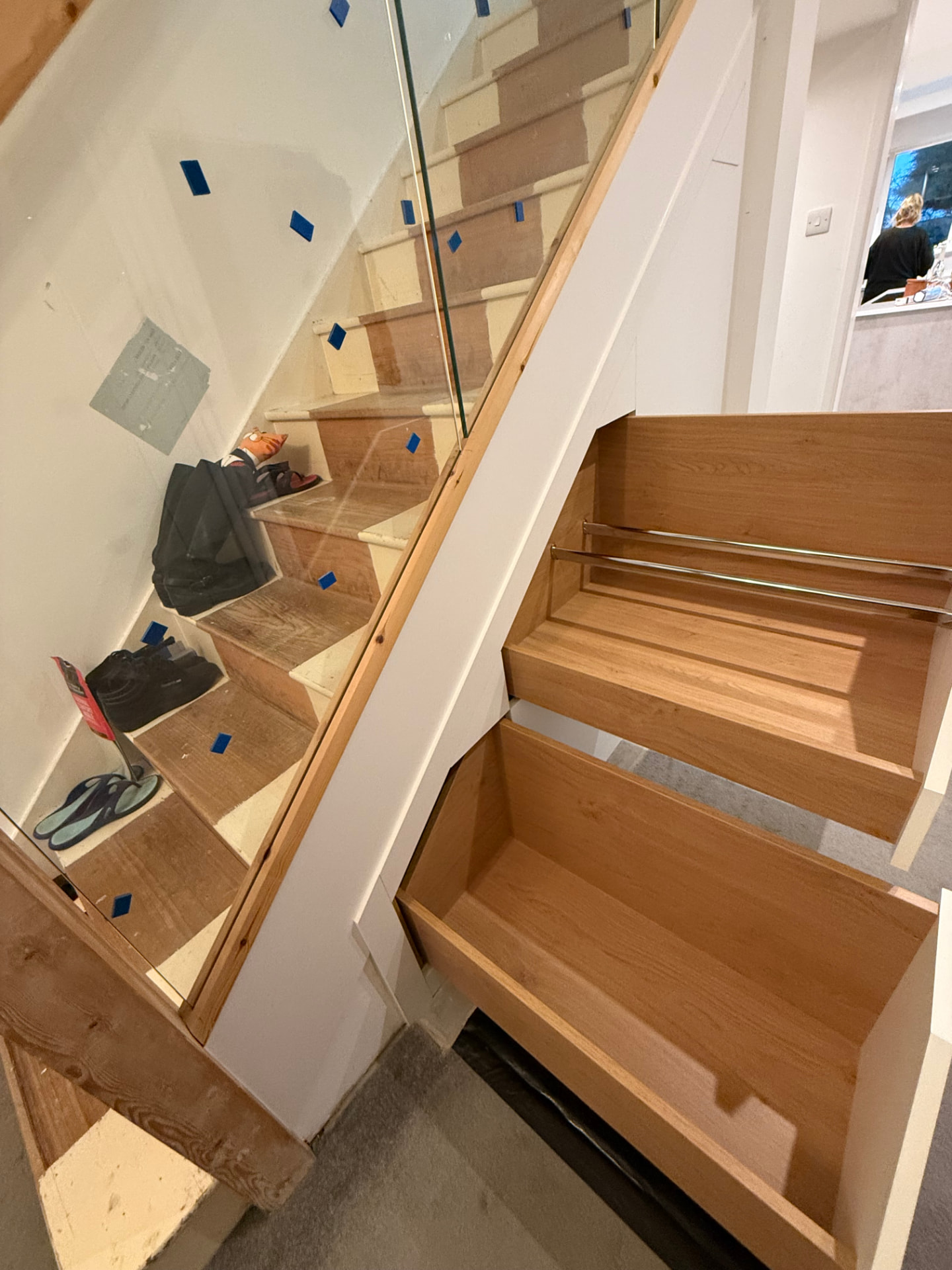 Deep oak pull-out shoe storage fitted beneath a staircase